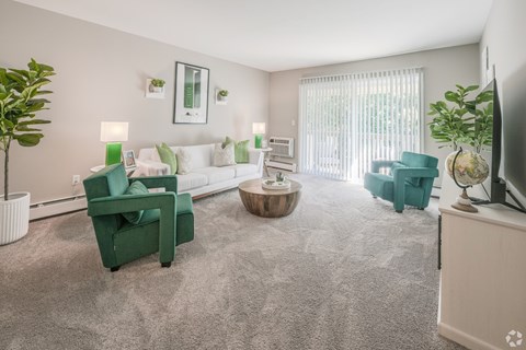 A living room with green chairs and a grey carpet.